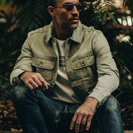 fit model wearing The HBT Jacket in Washed Olive, sitting down