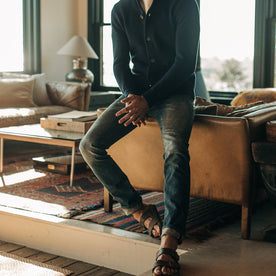fit model wearing The Slim Jean in Organic Selvage 12-month Wash, sitting against couch