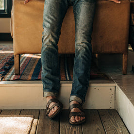 fit model wearing The Slim Jean in Organic Selvage 12-month Wash, cuffed with birks