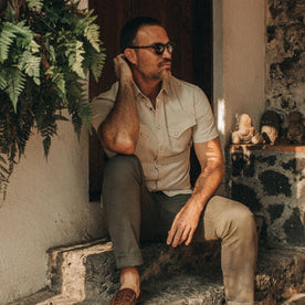fit model wearing The Short Sleeve Western in Natural, sitting on step