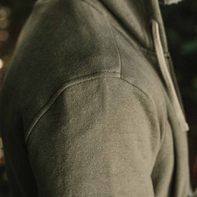 our fit model wearing The Après Hoodie in Olive—cropped shot of shoulder