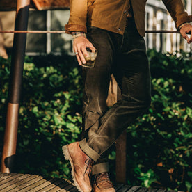 our fit model wearing The Camp Pant in Olive Corduroy—drinking a glass of whiskey