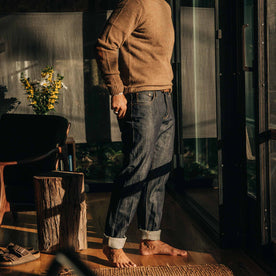 our fit model wearing The Democratic Everyday Jean—standing indoors looking right