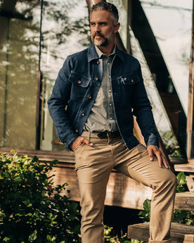 The Long Haul Jacket in Indigo Boss Duck—standing next to cabin, Outerwear by Taylor Stitch