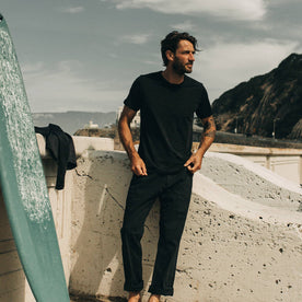 our fit model wearing The Merino Tee— on the beach, in our black colorway 