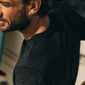 our fit model wearing The Merino Tee—in our black tee, cropped shot of shoulder