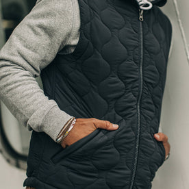 our fit model wearing The Vertical Vest in Charcoal—cropped shot of chest down with hands in pockets