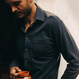fit model wearing The California in Navy Pique, holding mug, looking down