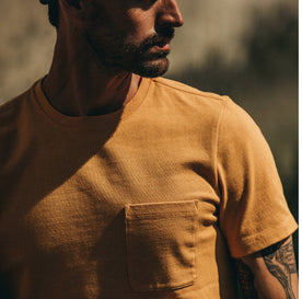 fit model wearing The Heavy Bag Tee in Saffron, looking right