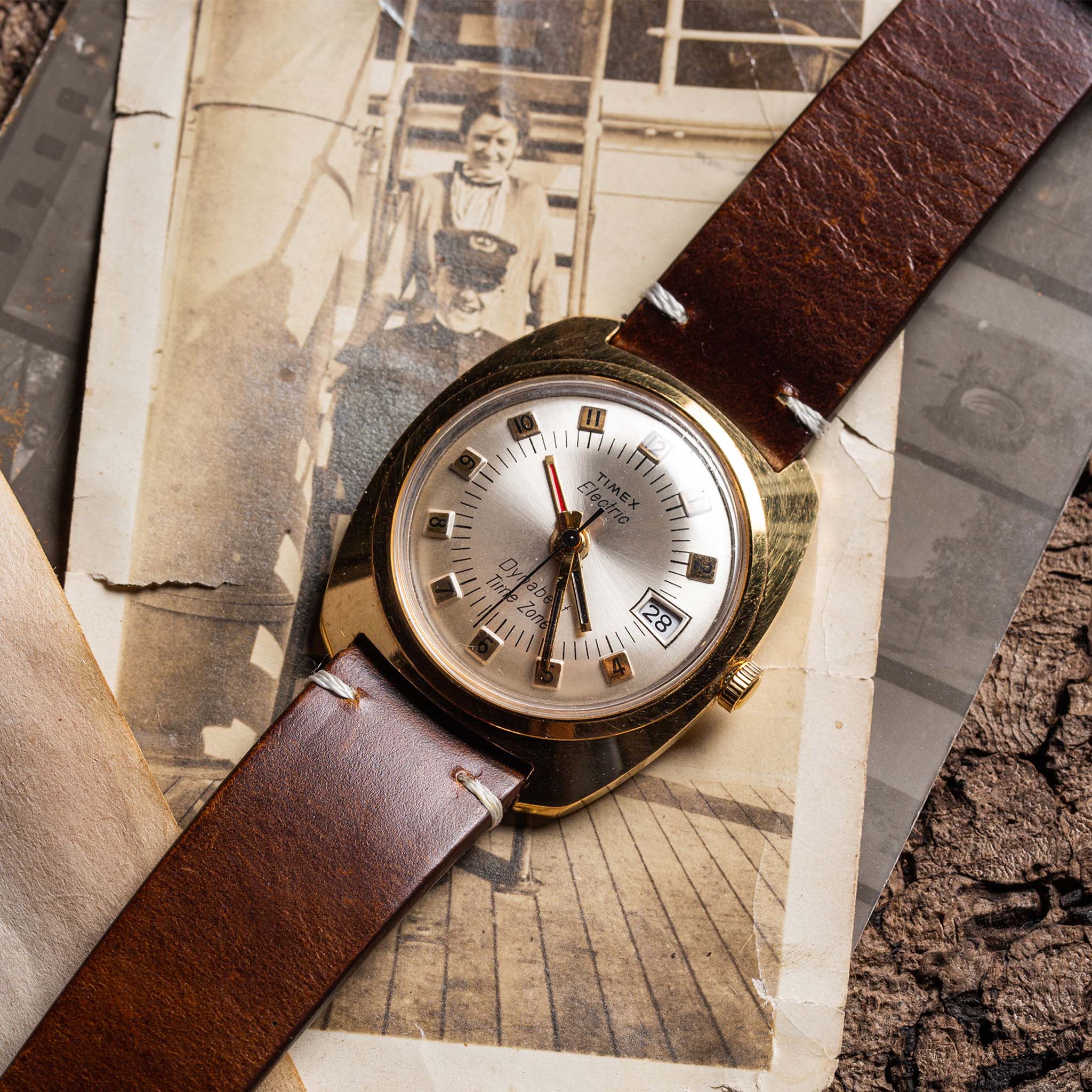 flatlay of the 1975 Timex Electric Dynabeat Time Zone, on a background of vintage photos, Accessories by Taylor Stitch