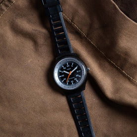 flatlay of the 1977 Timex Black Max on a brown background