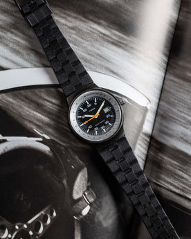 flatlay of the 1978 Timex Black Max, shown against a magazine, Accessories by Taylor Stitch