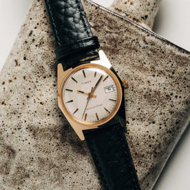 flatlay of the 1978 Timex Gold Marlin on a ceramic background