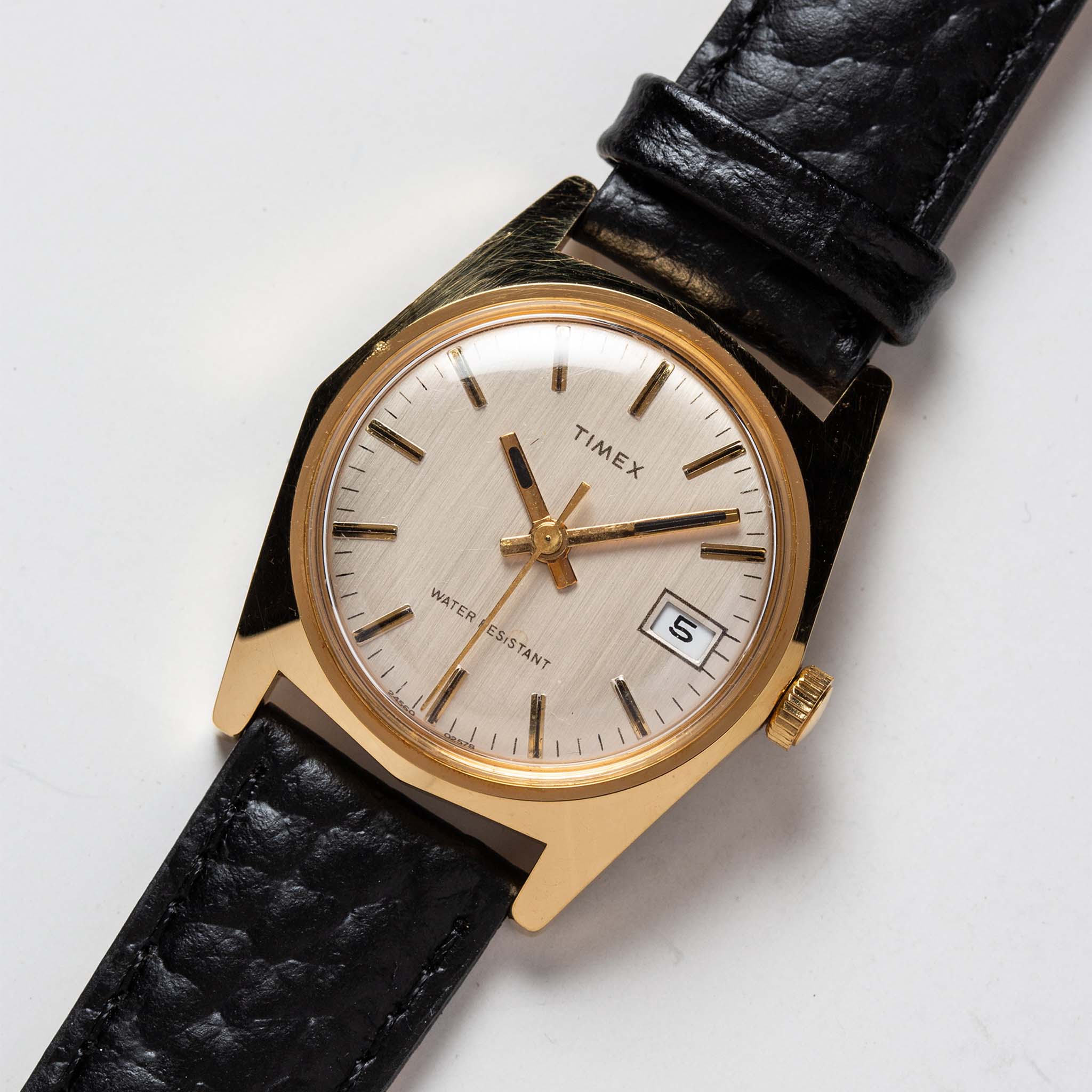 flatlay of the 1978 Timex Gold Marlin, shown close up, Accessories by Taylor Stitch
