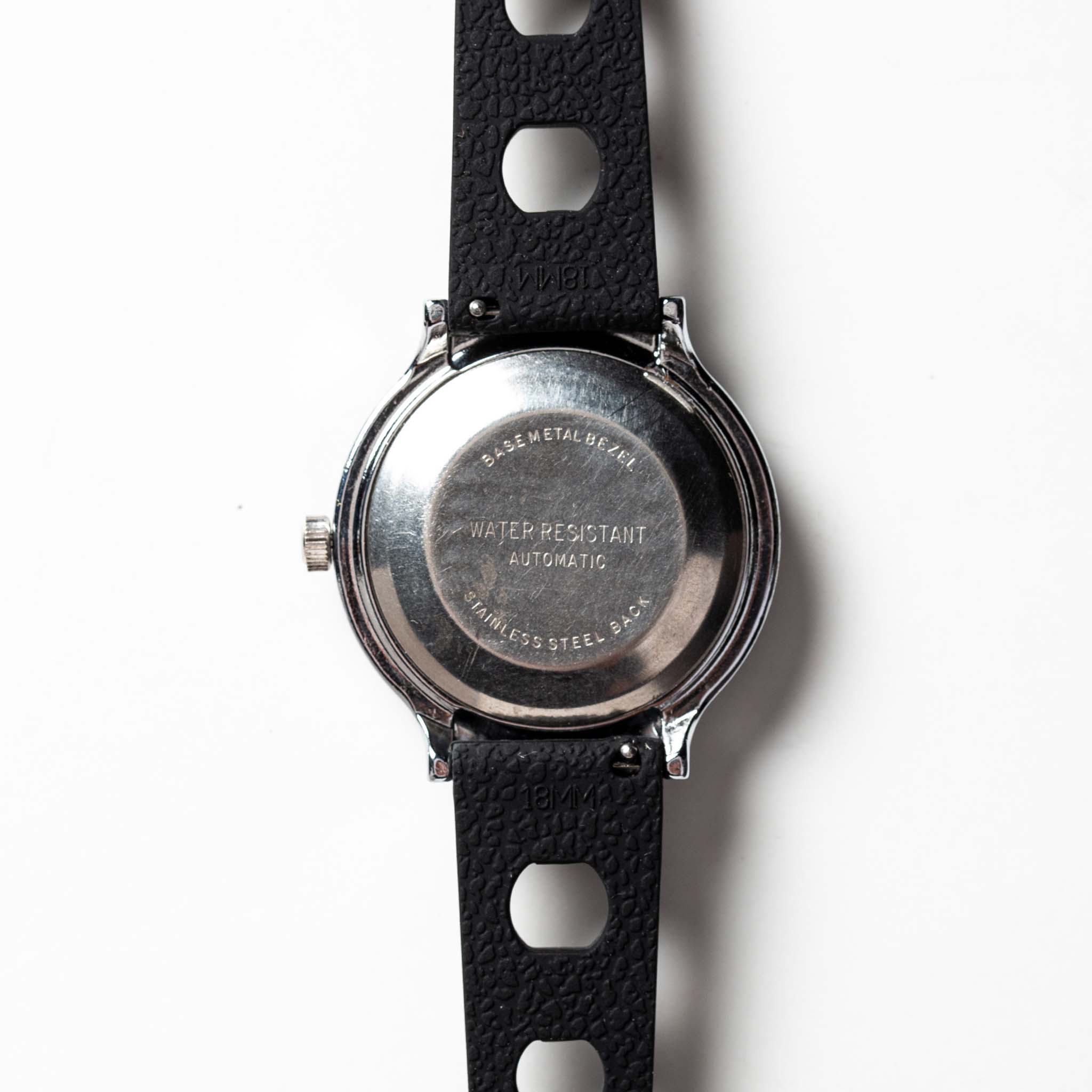 flatlay of the 1978 Timex Viscount M109, shown from the back, Accessories by Taylor Stitch