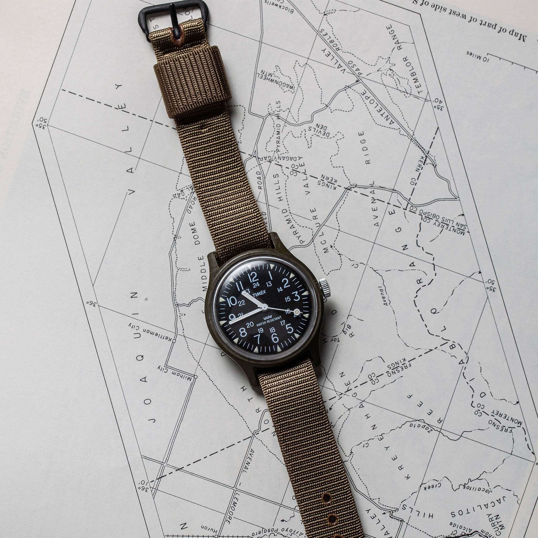 flatlay of the 1991 Timex Camper on a map, Accessories by Taylor Stitch