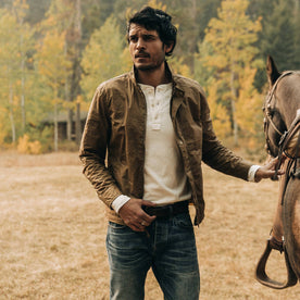 fit model wearing The Bomber Jacket in Field Tan Wax Canvas, with horse