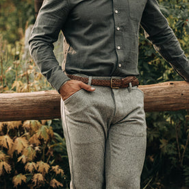 fit model wearing The Camp Pant in Heather Grey Wool—resting against fence