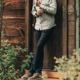 our fit model wearing The Camp Pant in Navy Donegal Herringbone—standing near shed
