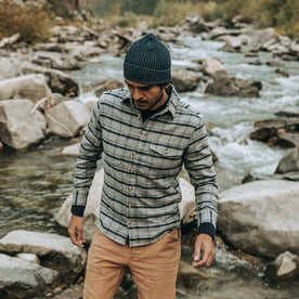 fit model wearing The Crater Shirt in Ash Plaid, walking near creek