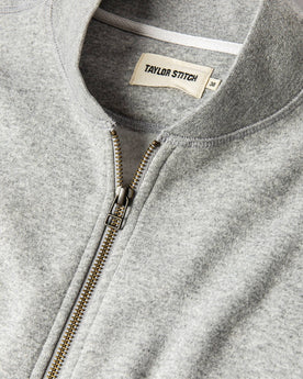 material shot of The Heavy Bag Bomber in Heather Grey Fleece top zipper, collar, and tag visible, Knits by Taylor Stitch