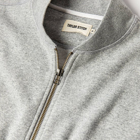 material shot of The Heavy Bag Bomber in Heather Grey Fleece top zipper, collar, and tag visible