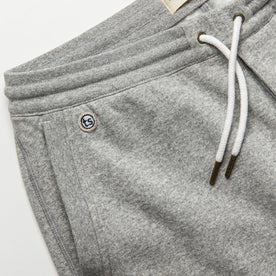 material shot of The Heavy Bag Short in Heather Grey Fleece with left side pocket visible with TS embroidered logo