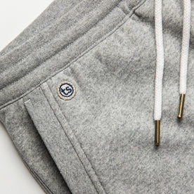 material shot of The Heavy Bag Short in Heather Grey Fleece with TS embroidered logo visible above right side hand pocket