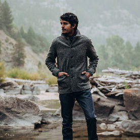 our fit model wearing The Ojai Jacket in Charcoal Wool—standing near a creek