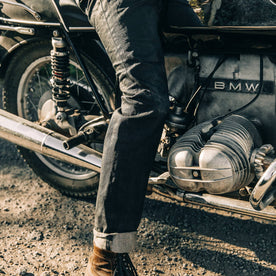 fit model wearing The Slim Jean in Black Over-dye Selvage, on bike