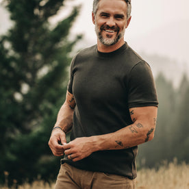 our fit model wearing The Heavy Bag Waffle Short Sleeve in Olive—smiling, looking ahead