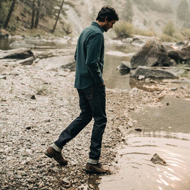 fit model wearing The Yosemite Shirt in Deep Ocean—walking into creek water