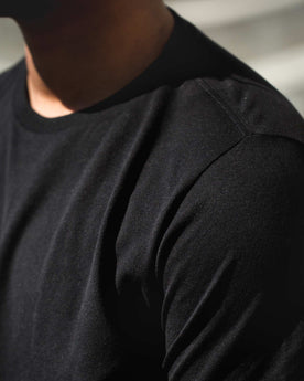 Detail shot of James wearing the black tee, Knits by Taylor Stitch