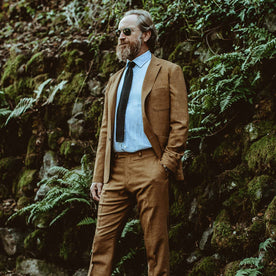 Our fit model in a garden wearing a gold suit