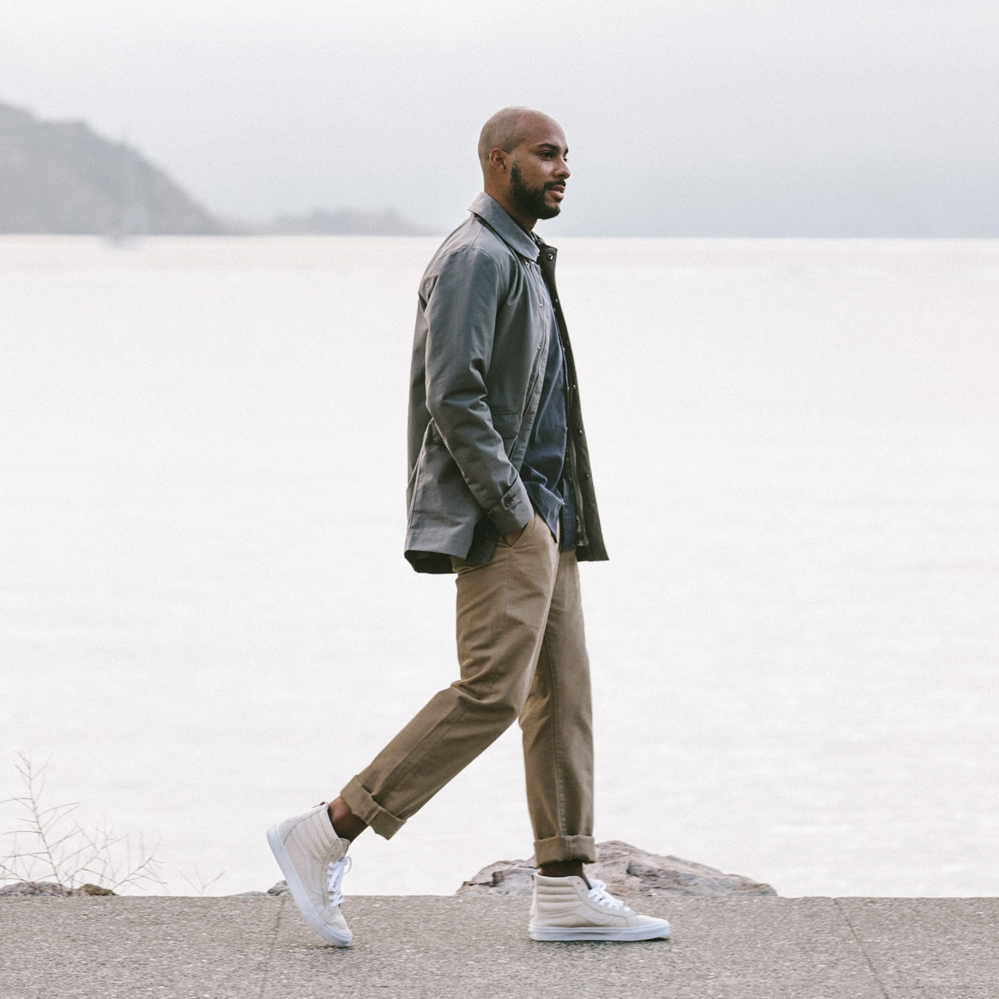 Alex walking along the shore side in the Primrose Jacket, Outerwear by Taylor Stitch