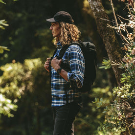Our fit model in The Crater Shirt in Blue Plaid hiking in the forrest 