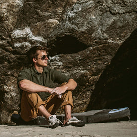 Our fit model bouldering next to the ocean in the Yosemite Shirt in Hunter