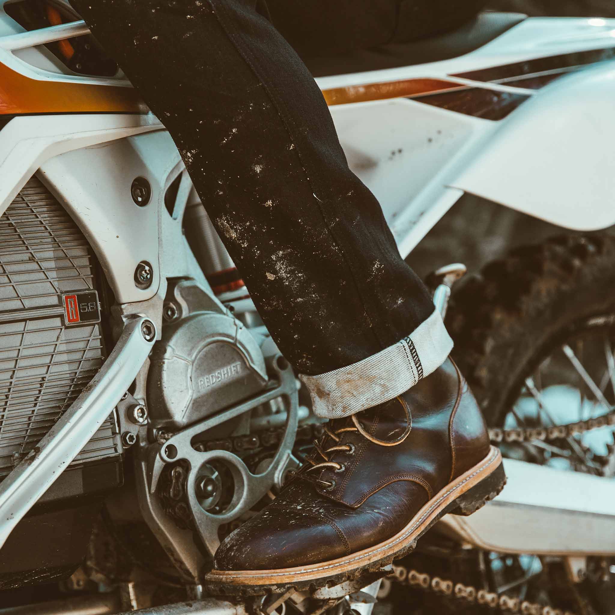 Allen with his motorcycle in the snow showing the cuff of his jeans, Denim by Taylor Stitch