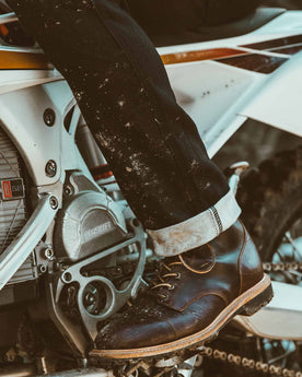 Allen with his motorcycle in the snow showing the cuff of his jeans, Denim by Taylor Stitch