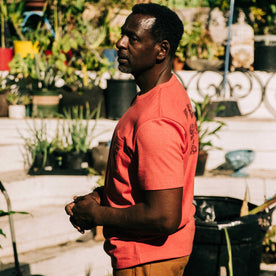 fit model in profile wearing The Heavy Bag Tee in Hibiscus