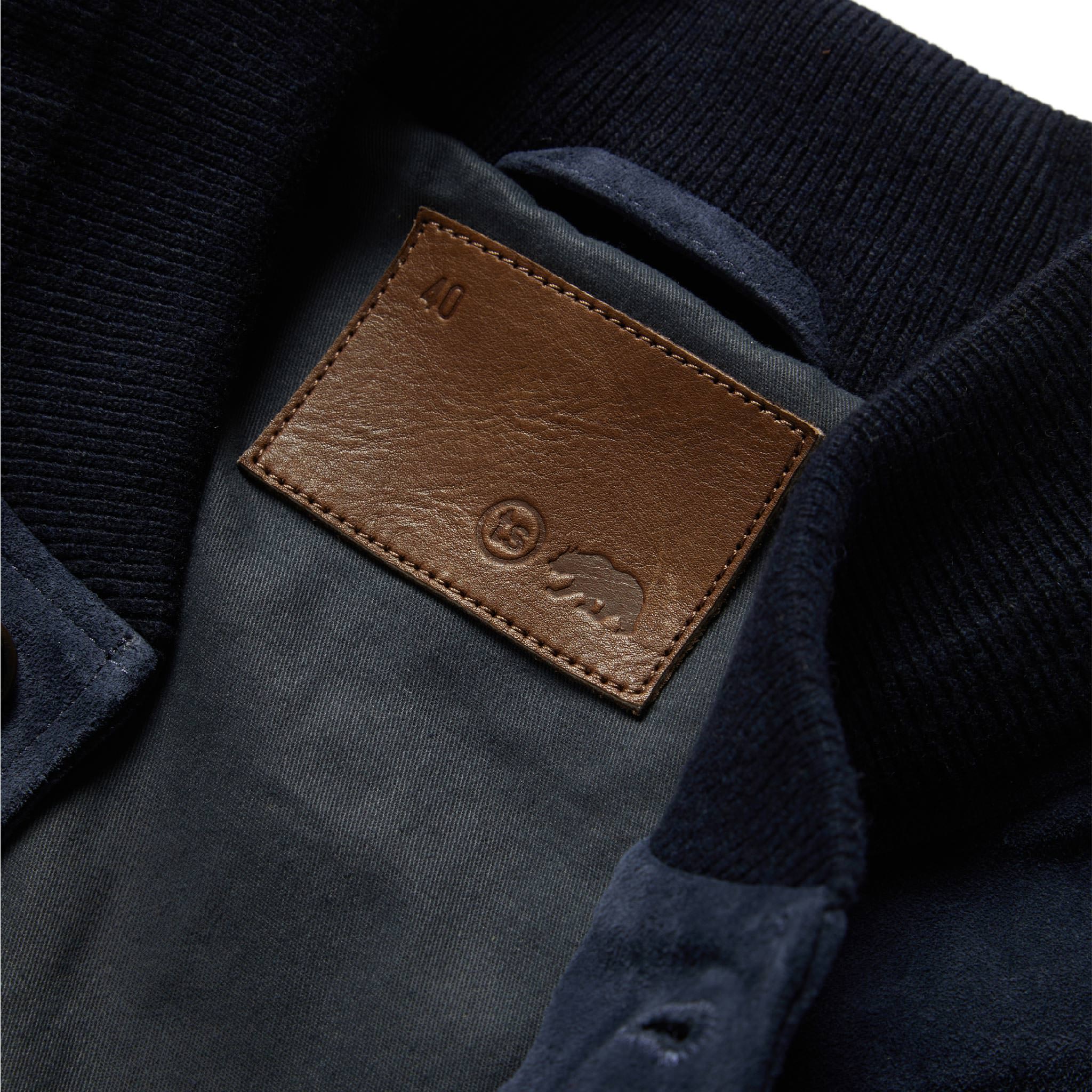 material shot of The Aviator Jacket in Midnight Suede's leather tag patch, Outerwear by Taylor Stitch