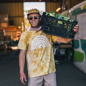 fit model balancing a basket of produce on his shoulders in The Organic Cotton Tee in Ecology Center