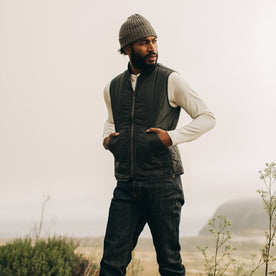 fit model wearing The Able Vest in Quilted Charcoal, hands in pockets