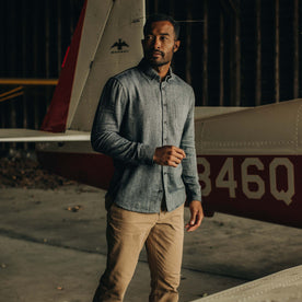 fit model posing next to a plane wearing The Jack in Navy Herringbone