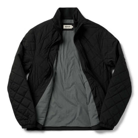 flatlay of The Vertical Jacket in Black, shown unzipped