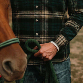 fit model wearing The Ledge Shirt in Deep Sea Plaid holding a rope
