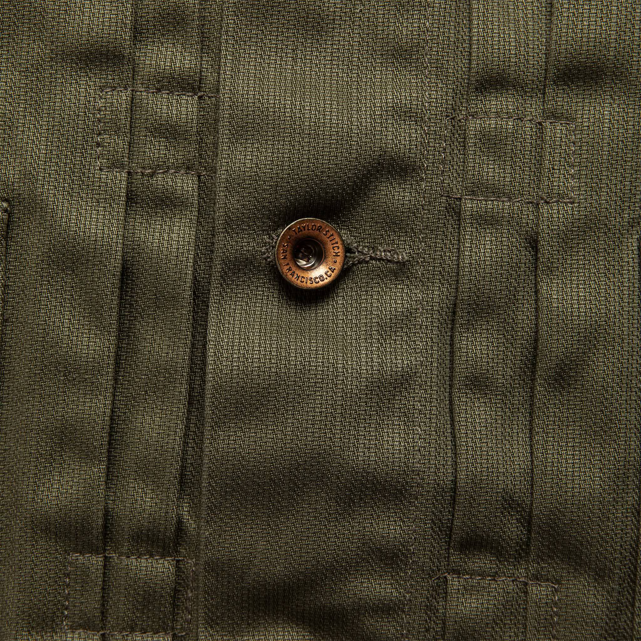material shot of The Ryder Jacket in Yoshiwa Mills Olive highlighting front placket and button, Outerwear by Taylor Stitch