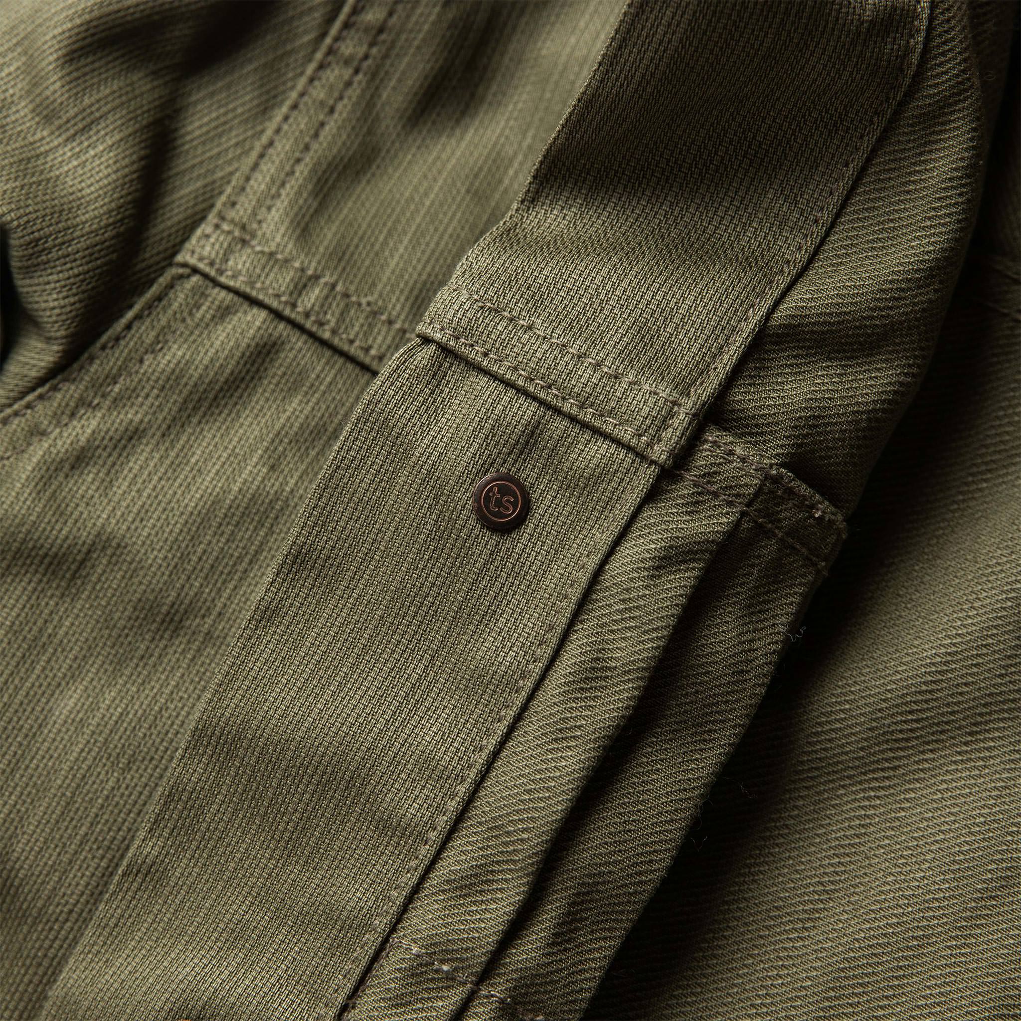 material shot of The Ryder Jacket in Yoshiwa Mills Olive showing branded button from the inside with double-needle construction, Outerwear by Taylor Stitch