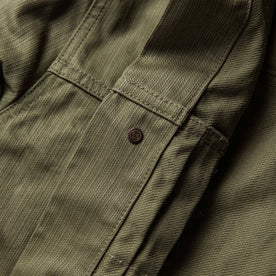 material shot of The Ryder Jacket in Yoshiwa Mills Olive showing branded button from the inside with double-needle construction
