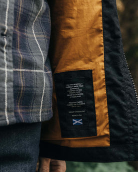 material shot of Halley Stevensons logo for The Clutch Jacket in Coal EverWax, Outerwear by Taylor Stitch